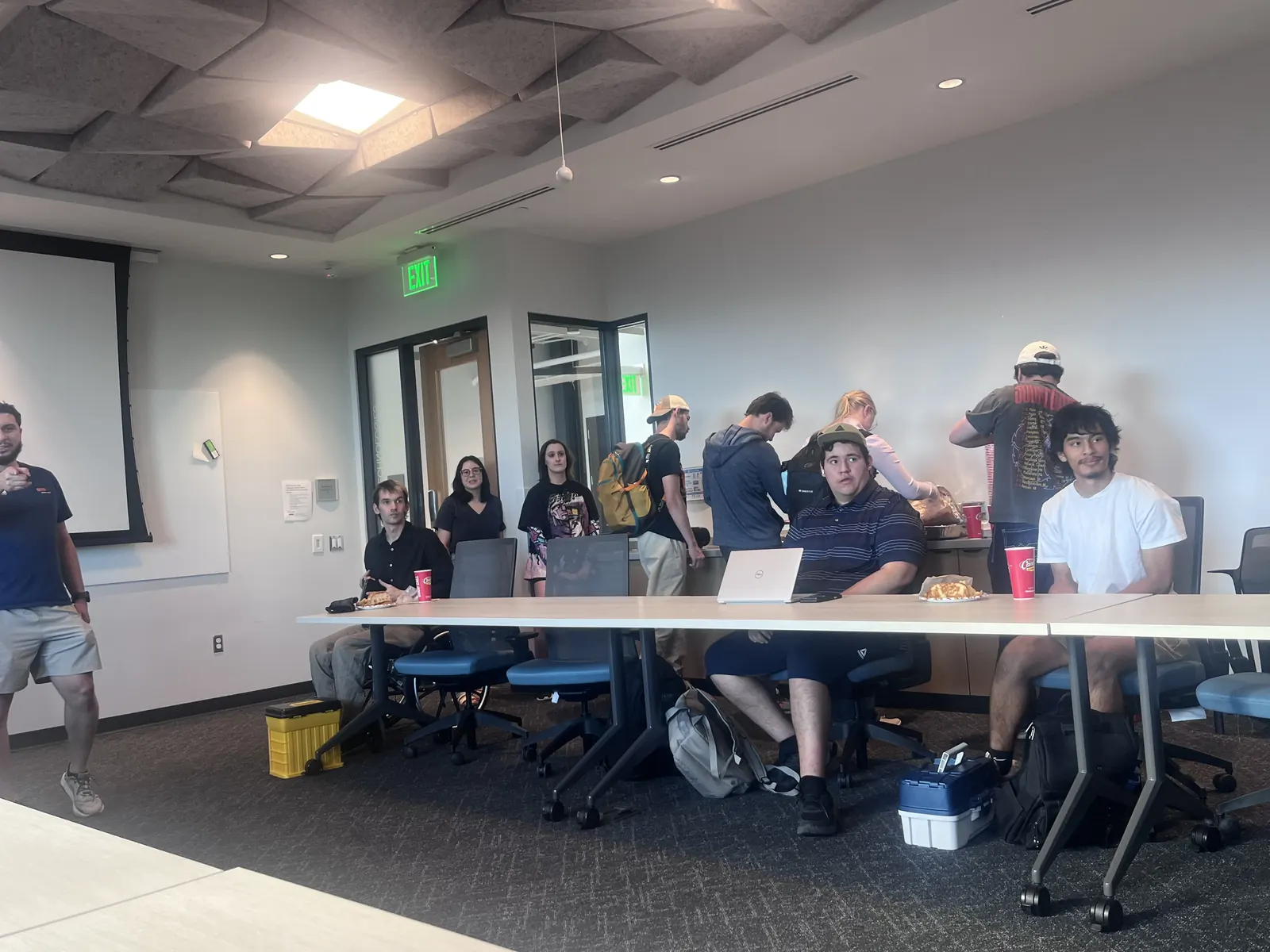 Members seated along the tables in a meeting room during a club meeting